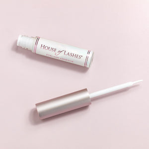 Clear Lash Glue on a pink background.