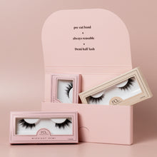 Demi Collection lashes placed in packaging on a pink background.