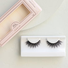 A Iconic false eyelashes in tray and packaging on a textured background.