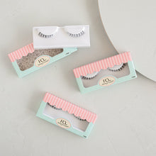 Three Darling Lower false eyelashes in packaging and on a textured background.