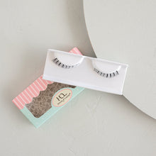 Darling Lower false eyelashes in packaging and tray on a textured background.