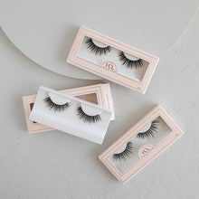 Three Ethereal Lite false eyelashes in packaging on a textured background.